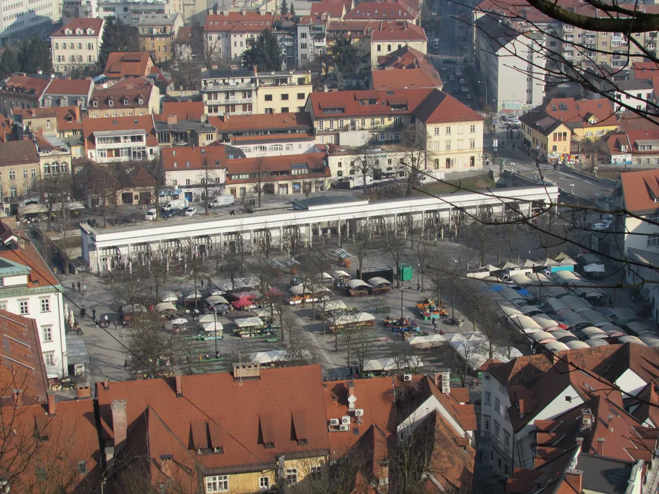 Pogled z Ljubljanskega gradu na osrednjo tržnico, arkade in mestne strehe.